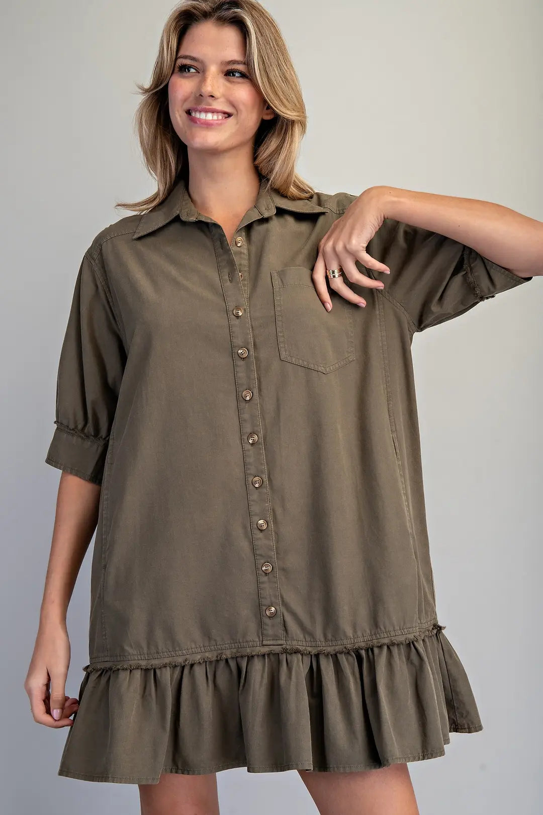Women’s olive green button front mini shirt dress with collar, chest pocket, short sleeves and ruffled drop hem.
