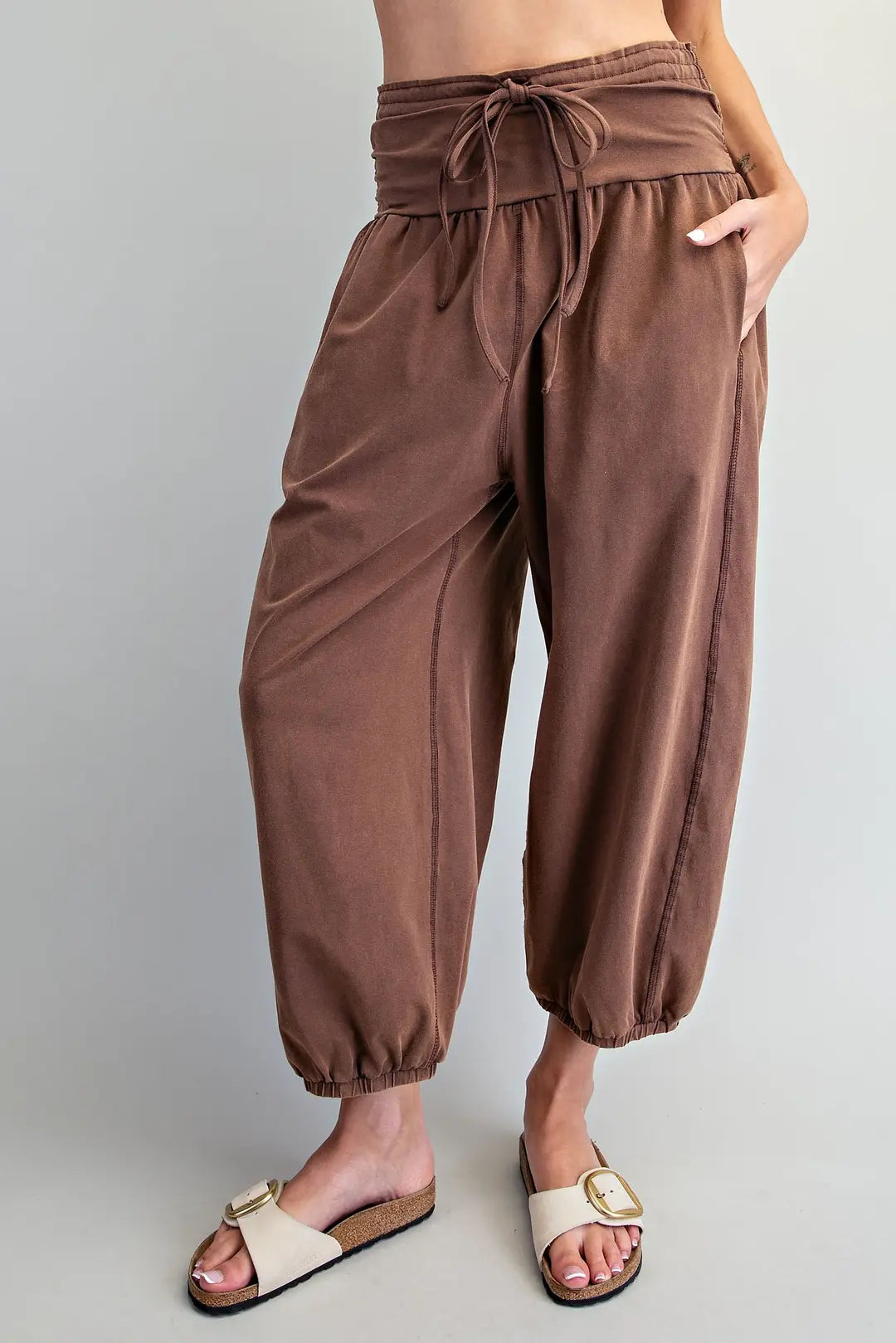 Women's chocolate brown mineral wash jogger pants with adjustable tie waistband, side pockets, exposed seam details and elastic ankle cuffs.
