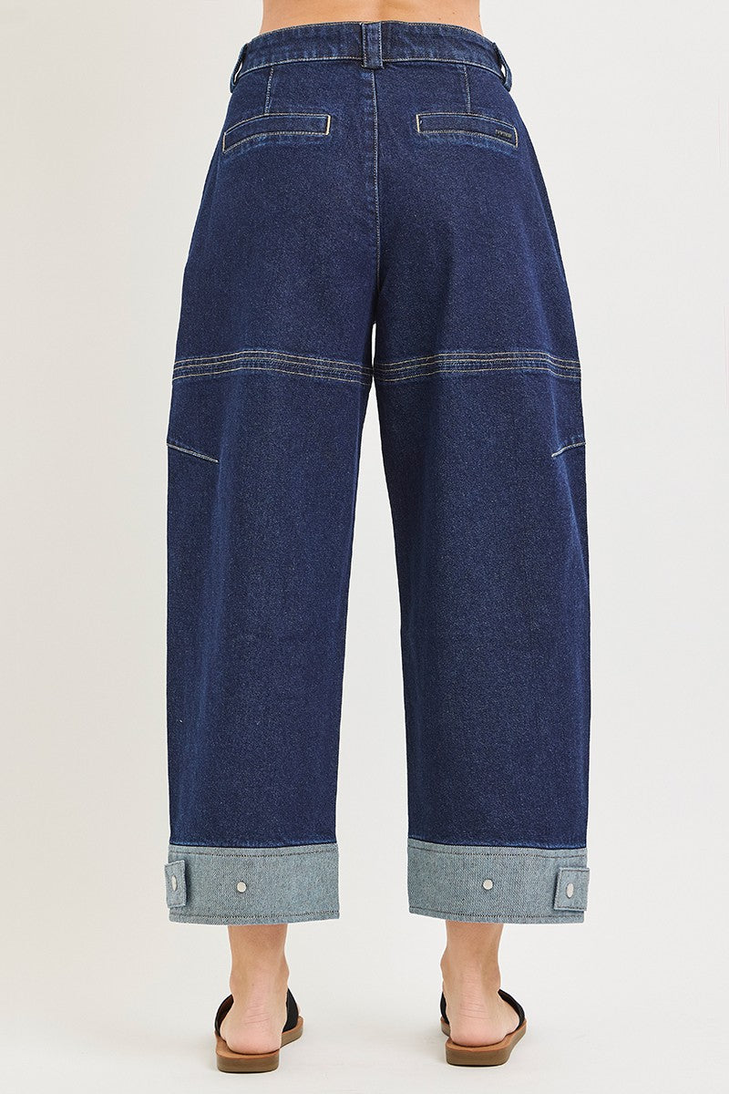 Plus size wide-leg denim jeans with cropped length, cuffed hem, dark blue wash, high waist, and visible stitching details, perfect for casual wear.