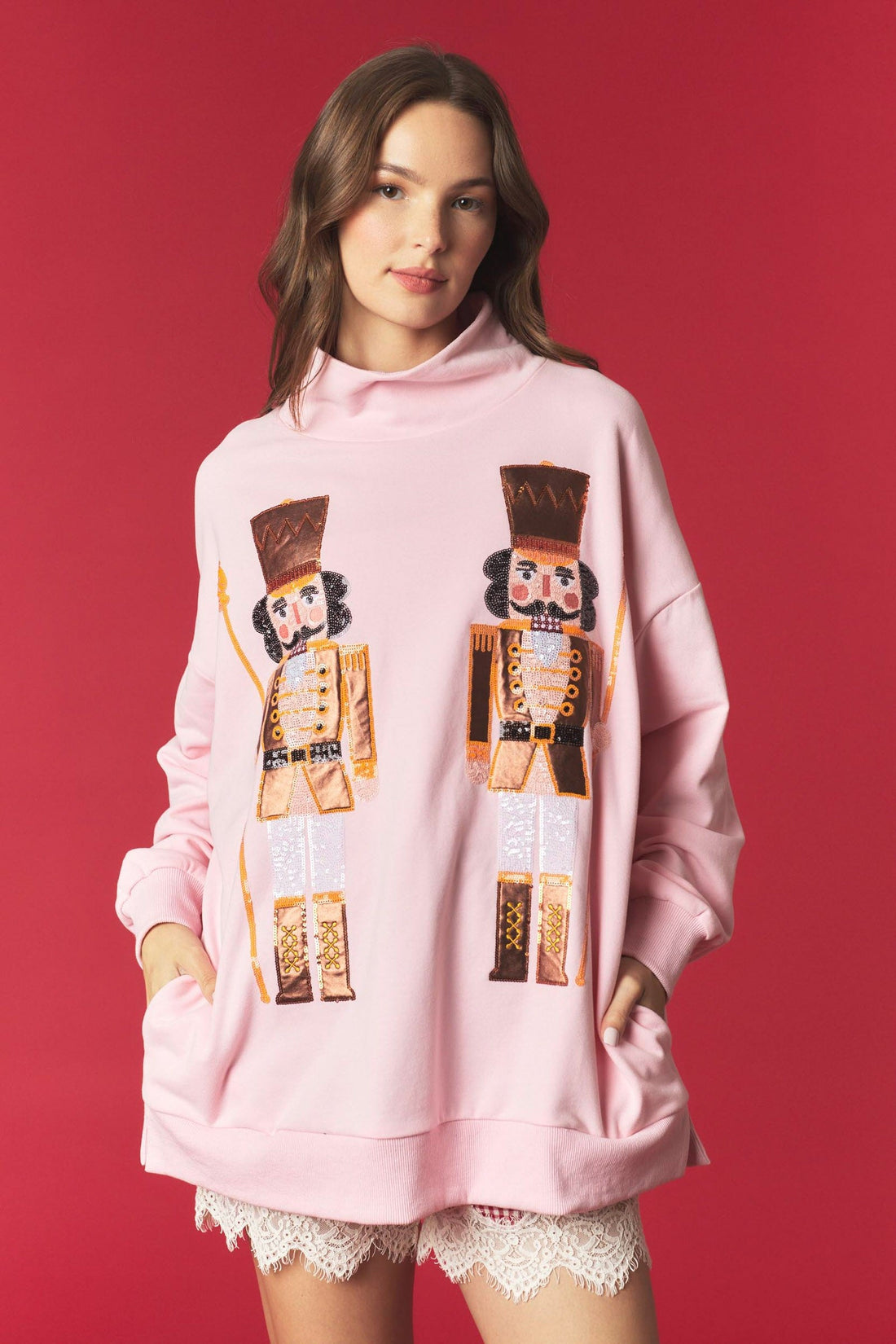 Peach Love California Nutcracker Christmas sweatshirt featuring shimmering foil accents, sequin embellishments, embroidered details, and a mock neckline in a cotton-rich fabric.