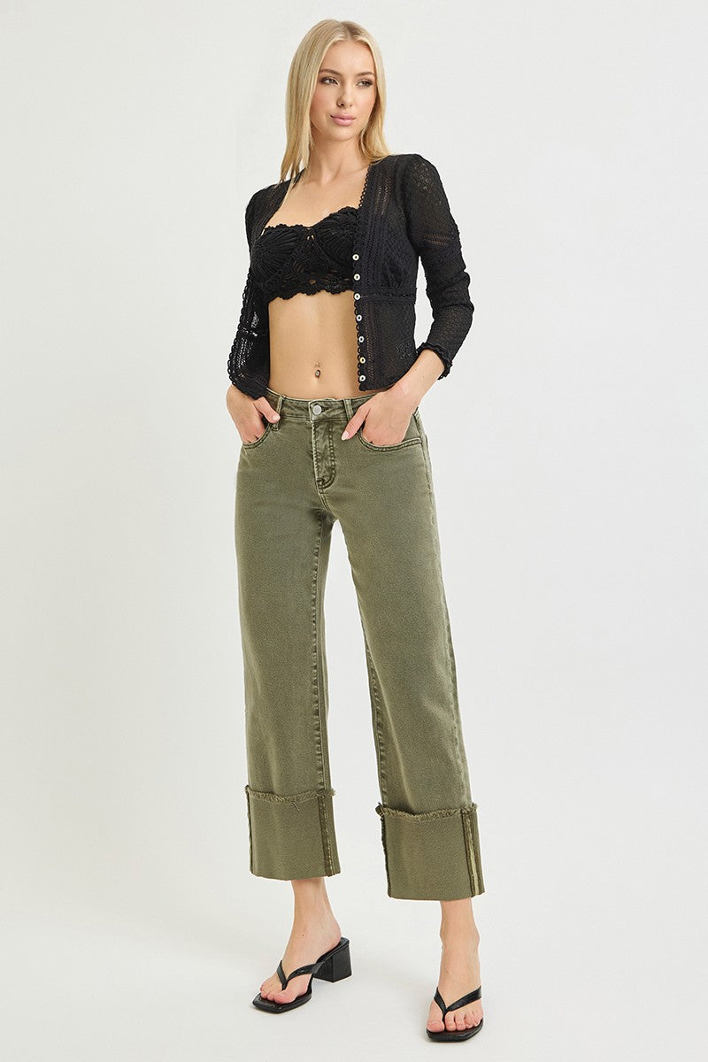Model wearing olive green wide leg jeans with cuffed hems, paired with black crochet crop top and black heels, casual style