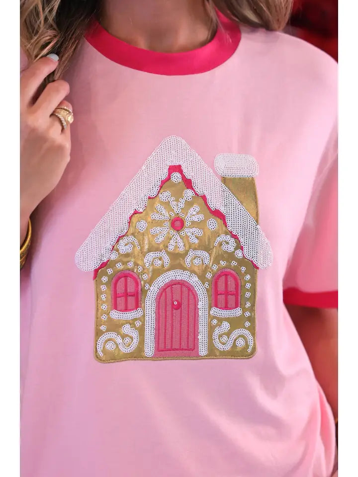 Close-up of the foil gingerbread house design with decorative sequin accents and embroidery on the Jess Lea Christmas tee.