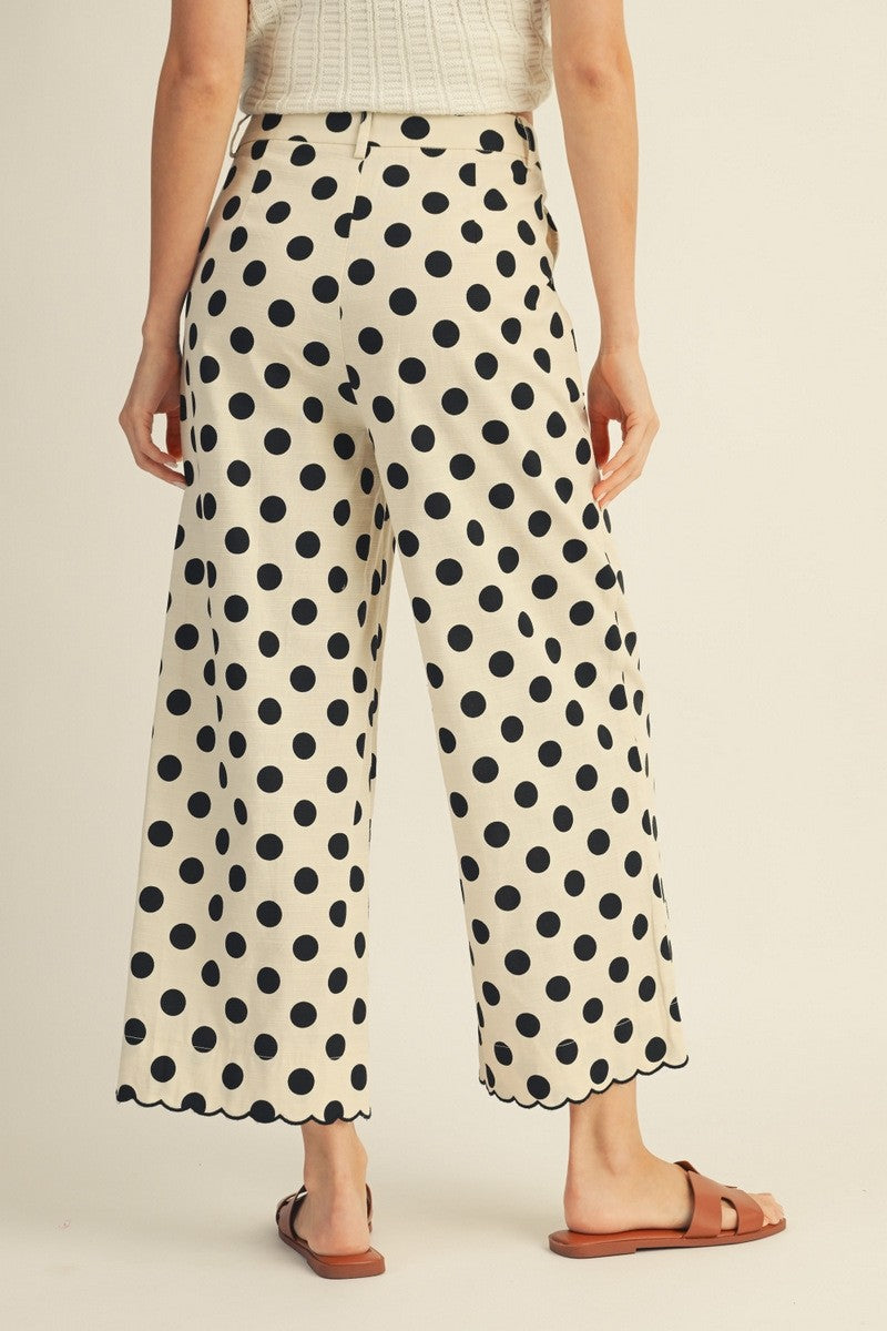 Woman wearing polka dot pants on a beige background