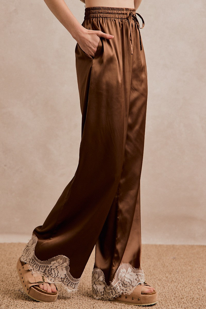 Close-up of So Me satin pants highlighting the delicate lace trim and stretchy elastic waistband.