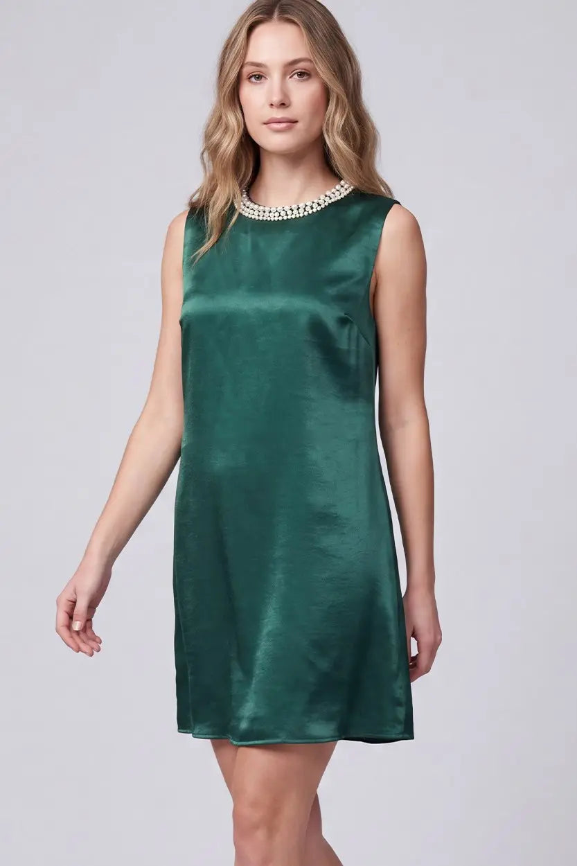 Women's emerald green satin mini dress featuring a sleeveless shift silhouette, faux pearl embellished round neckline, functional side pockets, and elegant satin finish.