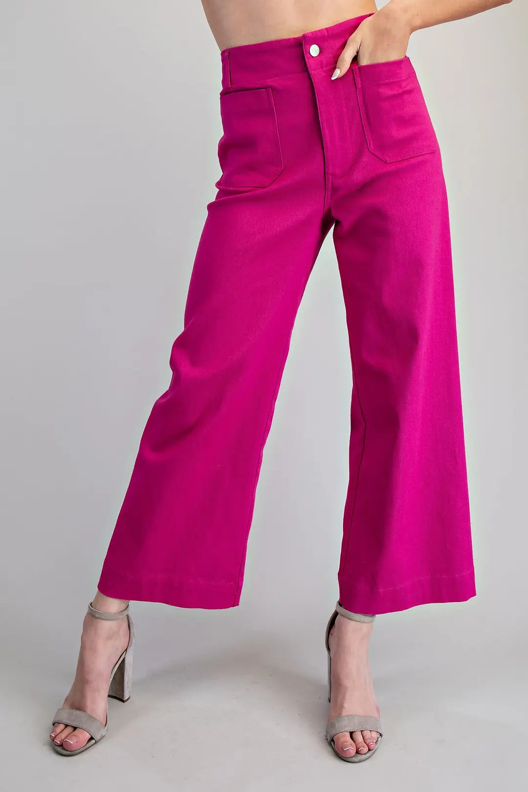 Women's hot pink high-rise wide leg pants with oversized front patch pockets, button closure, belt loops and ankle-length hem.