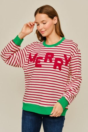 Woman wearing a red and ivory striped Jodifl Christmas sweatshirt with green contrast trim and textured MERRY lettering across the front.