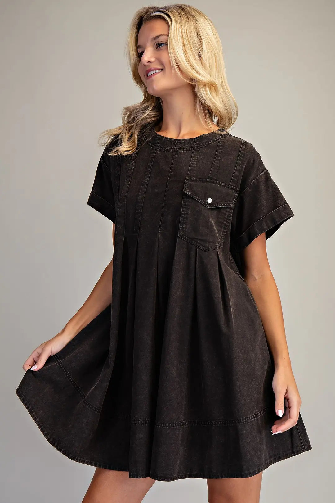 Women's black mineral wash short sleeve mini dress with vertical seam detailing, front chest pocket, side pockets and relaxed flowy silhouette.