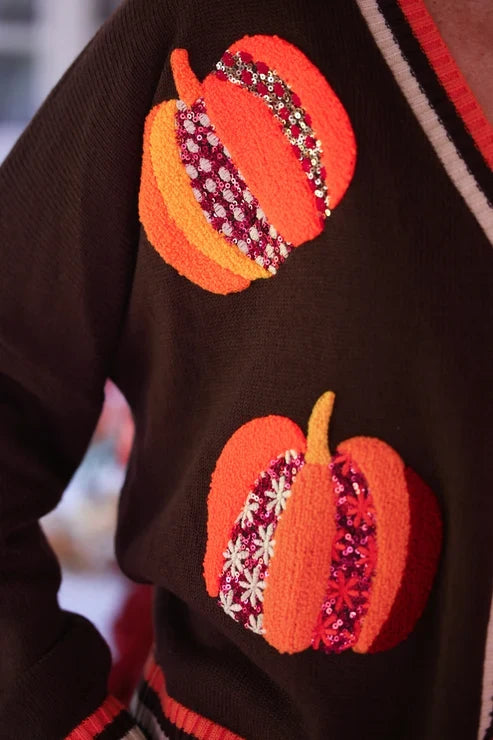 Detailed view of pumpkin appliqué on the brown knit cardigan, showcasing colorful sequins and floral embellishments for fall