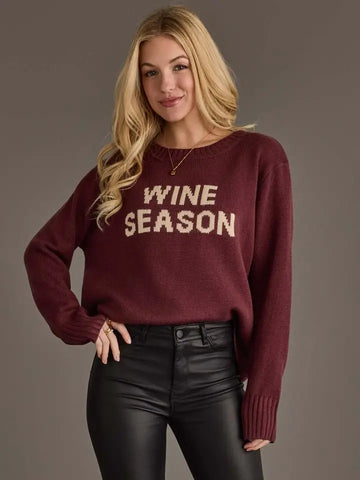 Women’s burgundy Wine Season graphic knit sweater with cream lettering, crew neckline, long sleeves, ribbed cuffs, and relaxed fit.