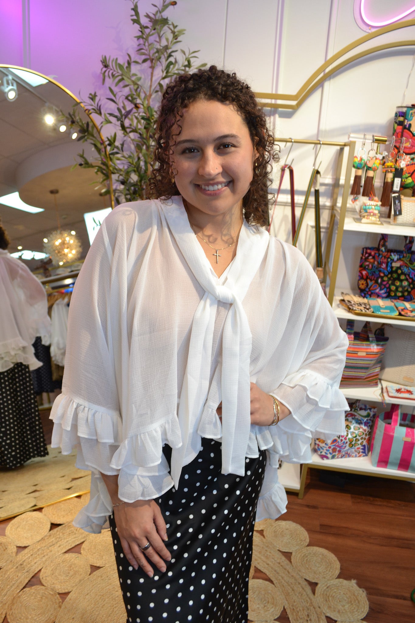 White tie-front blouse for women featuring dramatic ruffle sleeves, a relaxed fit, and feminine boutique style.