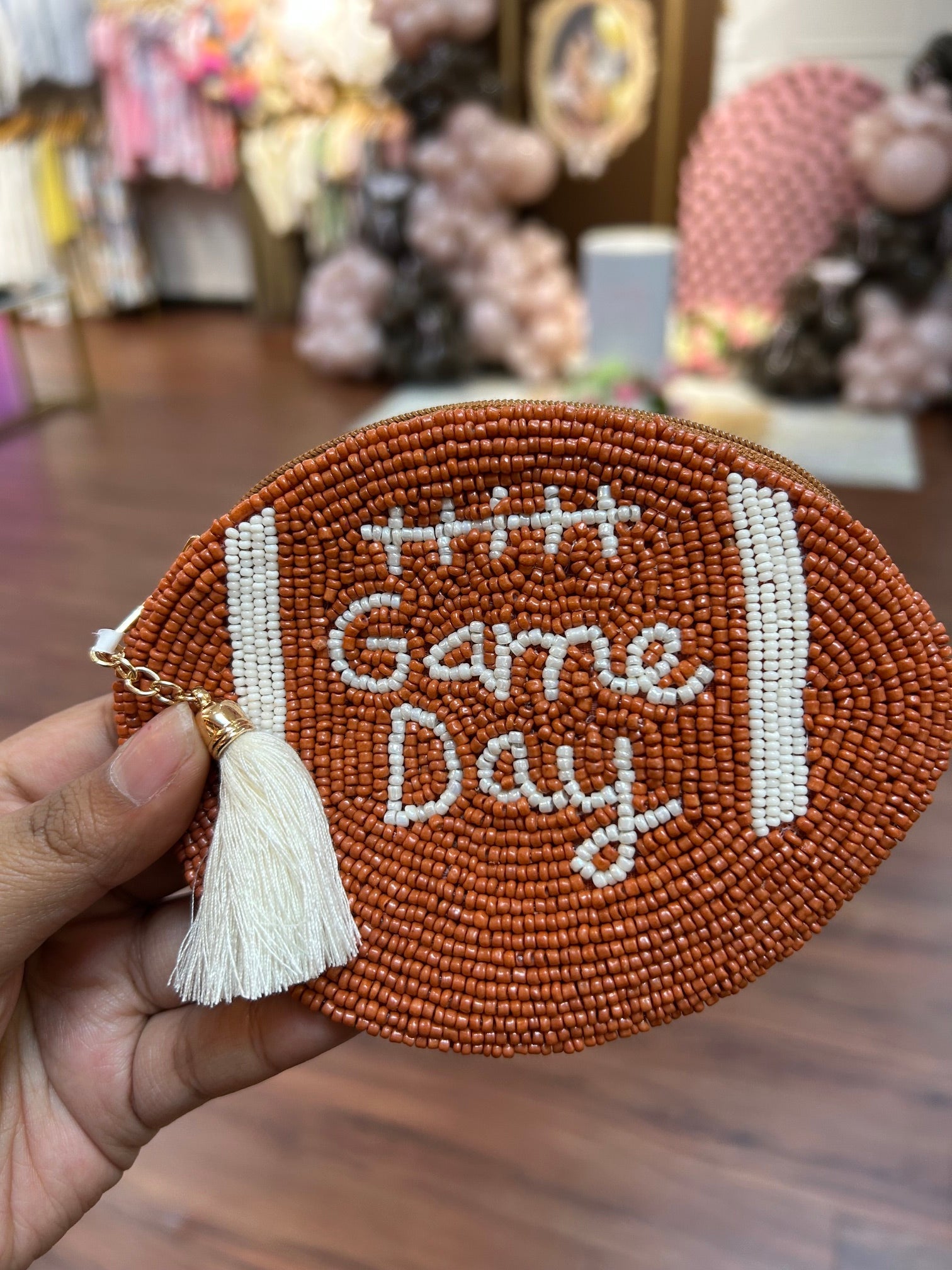 Football shaped pouch with beaded game day written out 