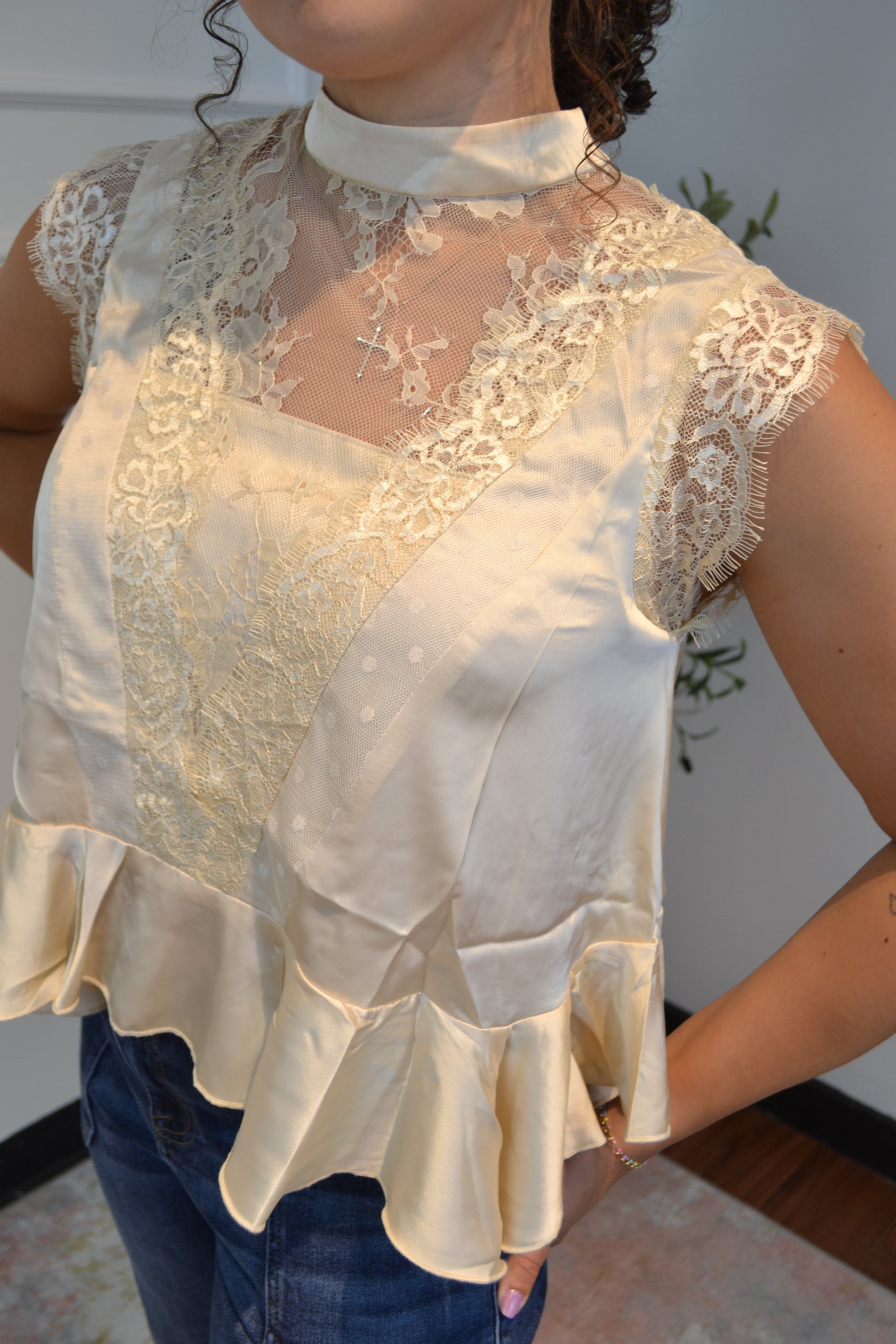 Elegant lace and satin peplum blouse styled with dark wash jeans.