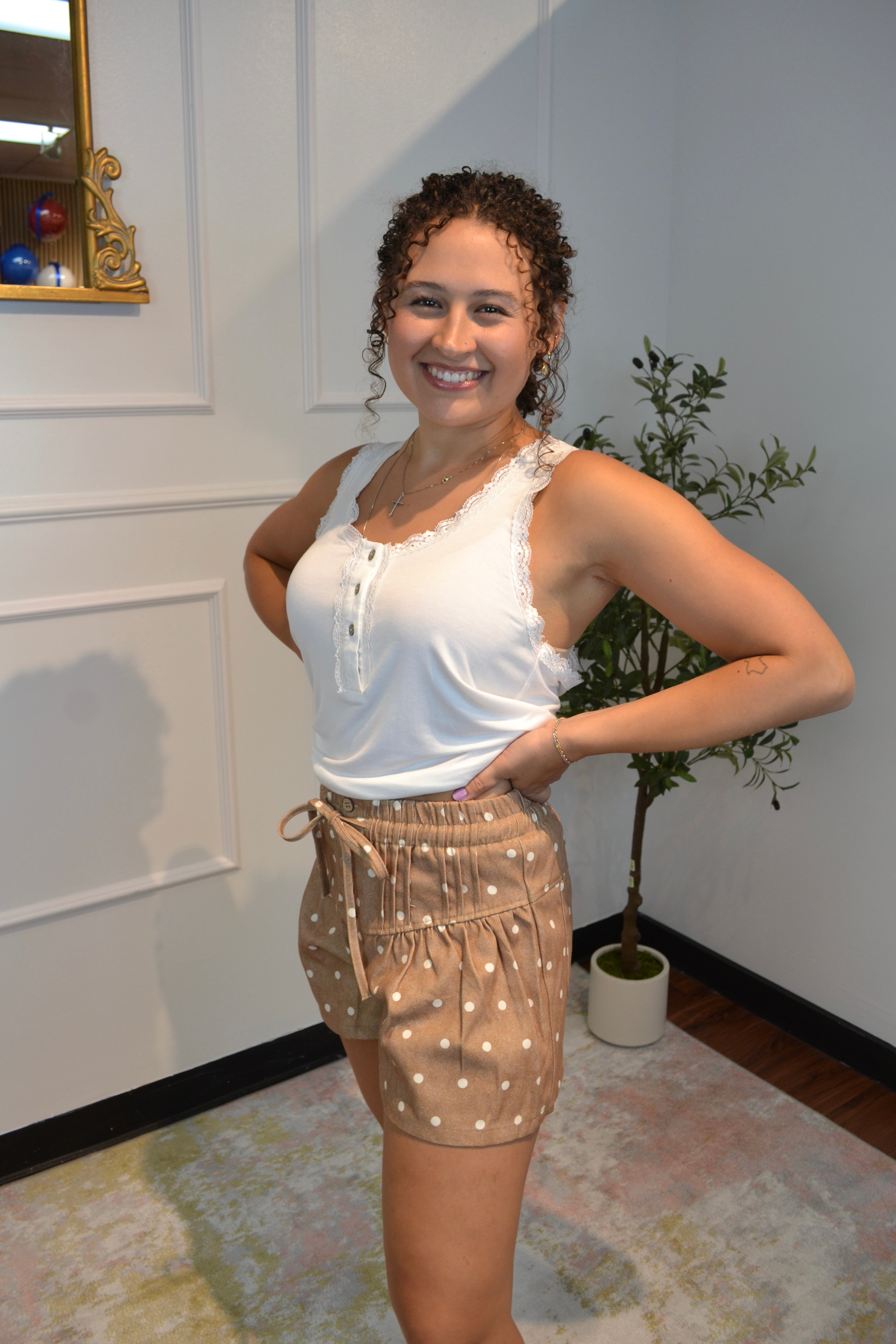 Front view of mocha shorts featuring white polka dots and button detail.