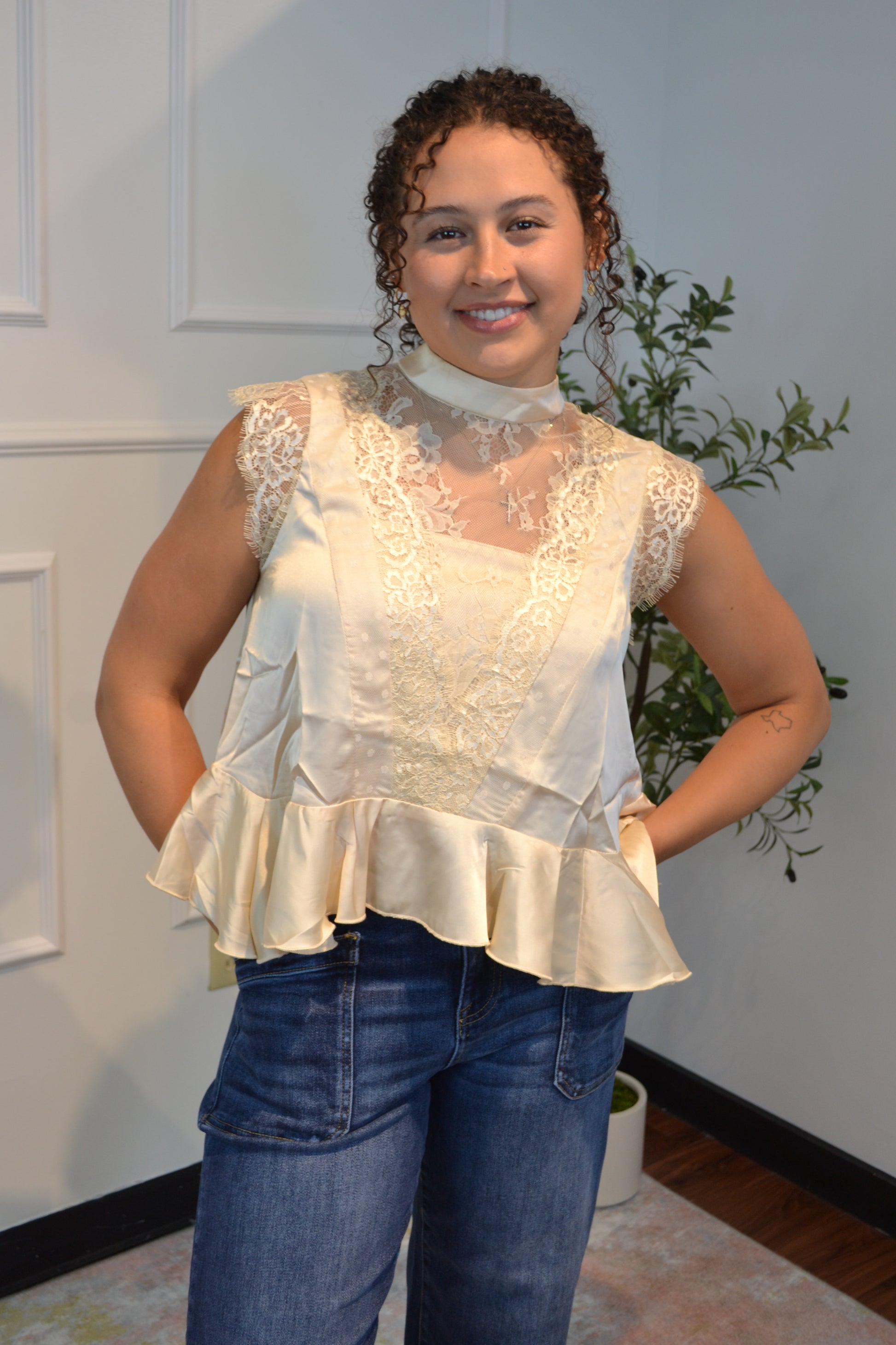 Women's ivory lace peplum top featuring sheer mesh and cap sleeves.