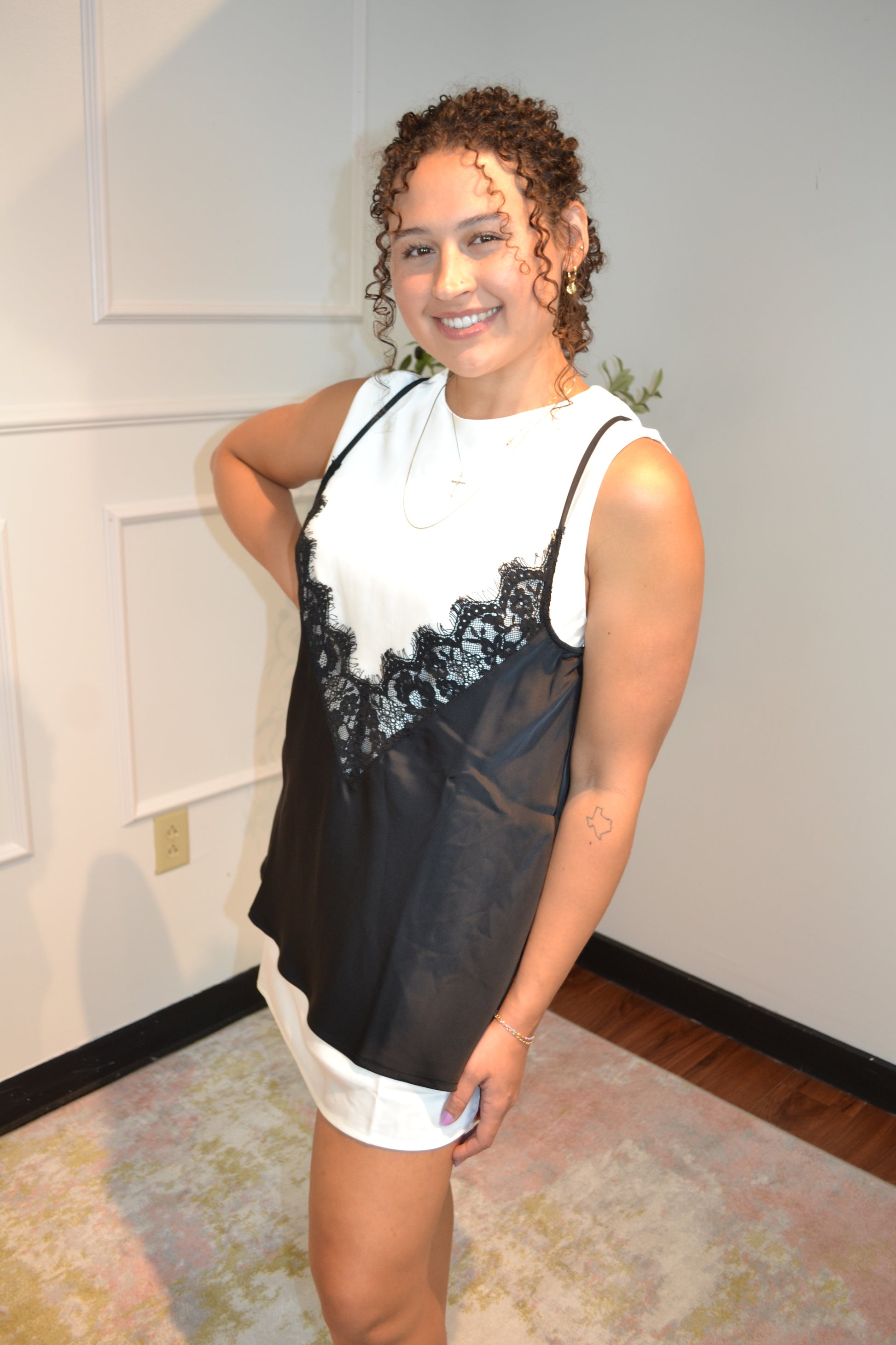 Elegant black lace mini dress styled with an ivory sleeveless underlayer.