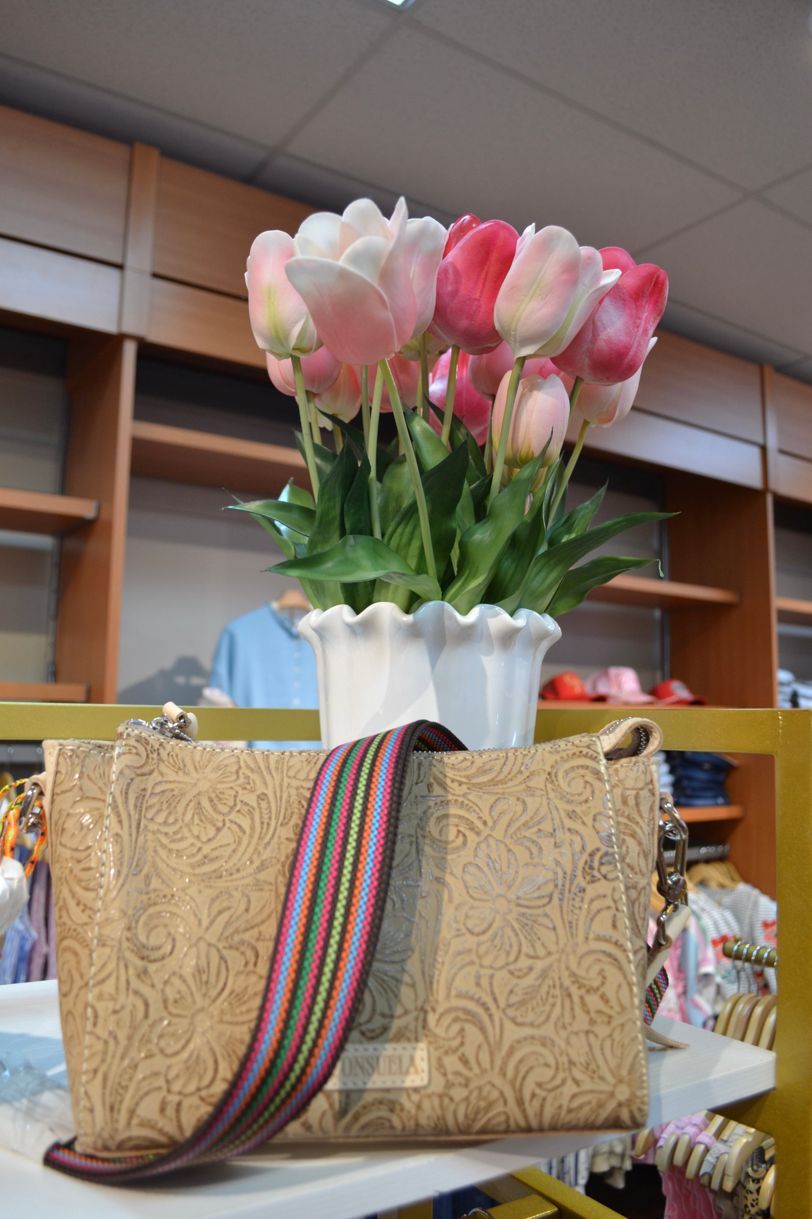 Beige embossed leather handbag with colorful striped strap