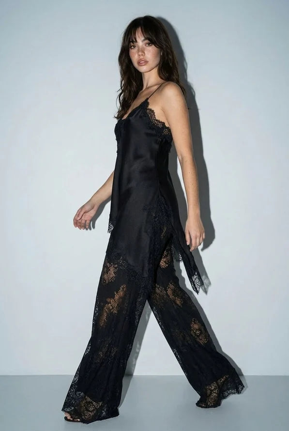 Black satin lace slip dress with spaghetti straps, lace detailing along the neckline and hem, and matching lace pants for elegant loungewear.