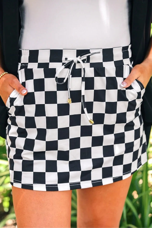 Women’s checkered skort featuring built-in shorts, side pockets, an elastic back waistband and adjustable drawstring.