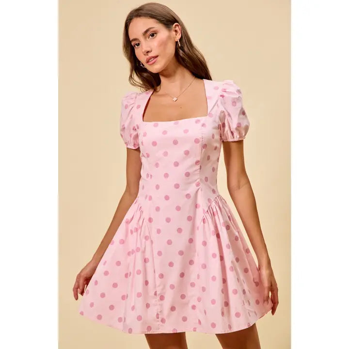 Pink polka dot mini dress with puff sleeves, square neckline, fitted bodice, and flared skirt, perfect for feminine boutique style.
