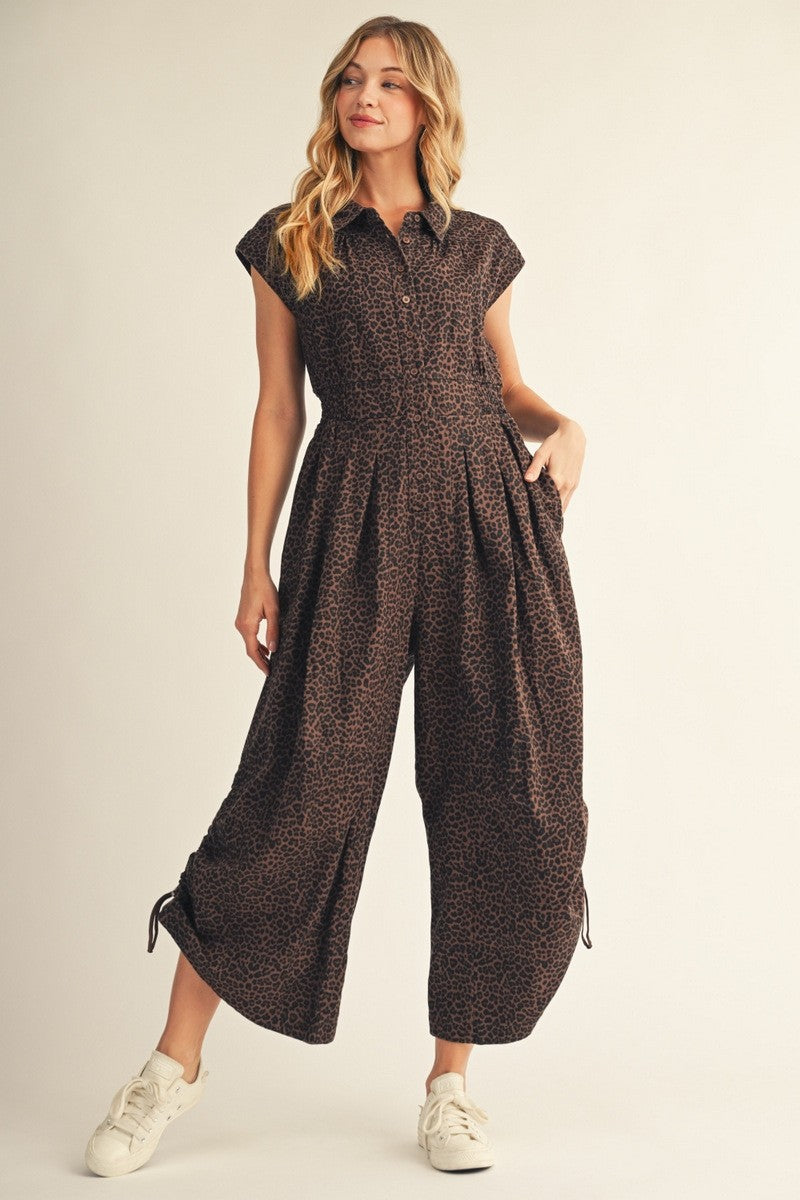 Brown and black leopard print women’s wide leg jumpsuit with collared button front, pockets and adjustable tie leg details.
