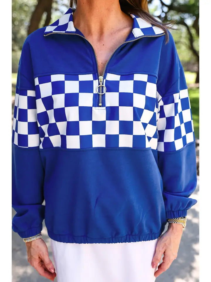 Women’s royal blue quarter zip pullover featuring a blue and white checkerboard panel, checkered collar and relaxed long sleeve silhouette.