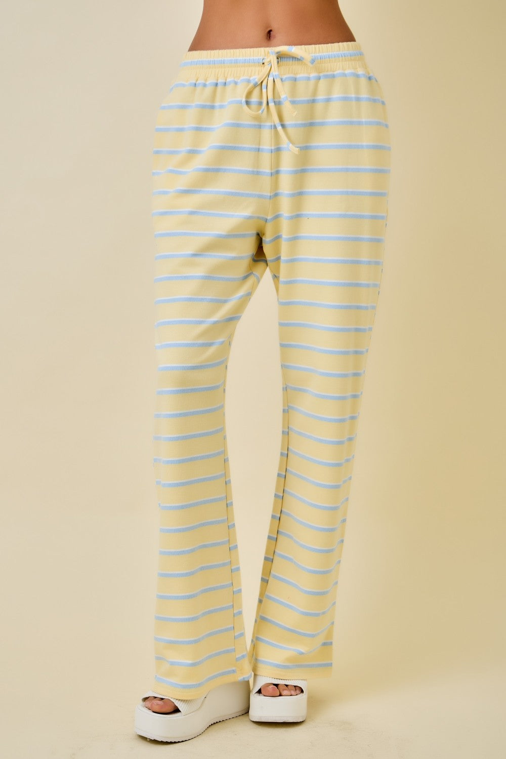 Women’s yellow and light blue striped wide leg pants with elastic drawstring waistband and relaxed full-length fit.