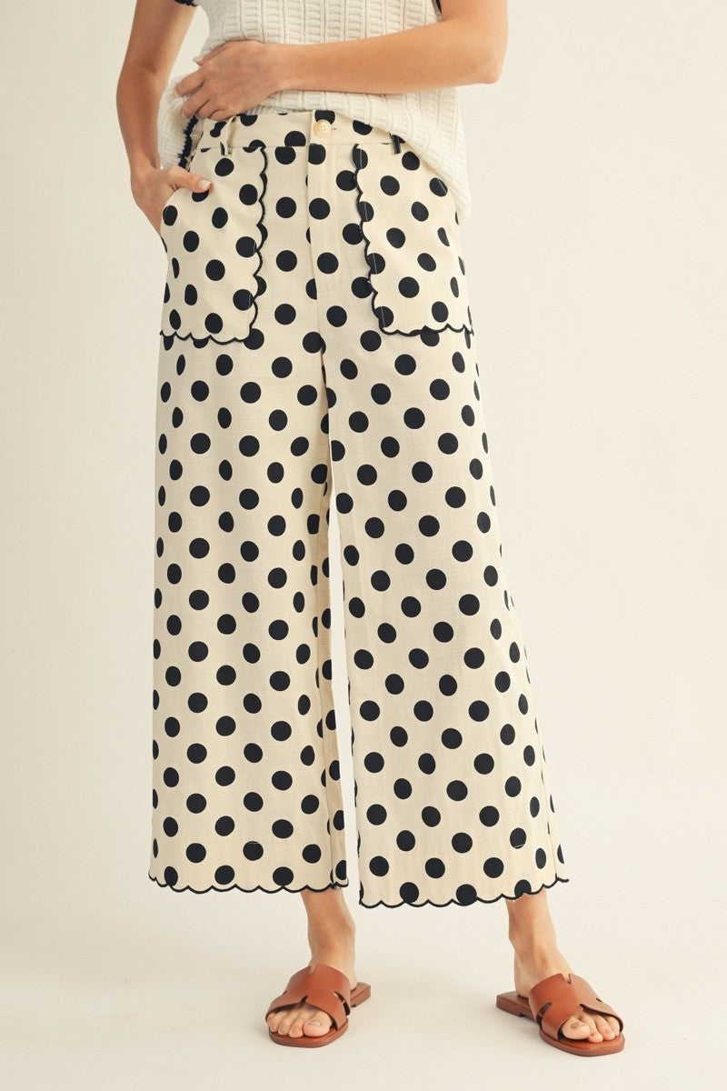 Person wearing polka dot pants on a plain background