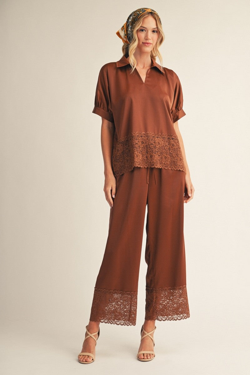 Chocolate brown satin two-piece set featuring a collared short-sleeve top with lace hem and matching wide-leg pants with lace trim.