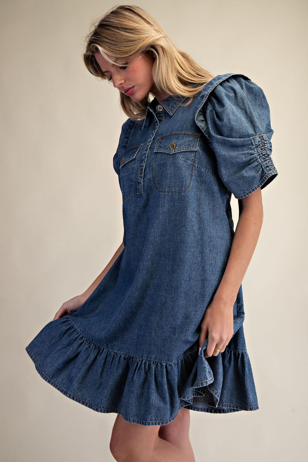 A collared button, front neckline with front flap pockets and a ruffle hem dress