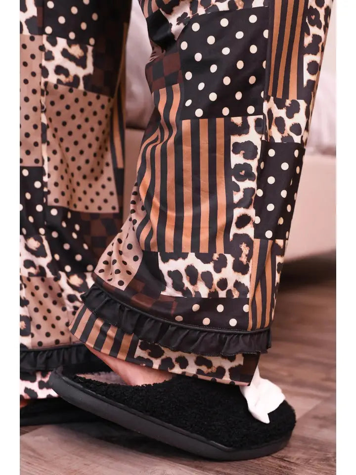 Close-up of the leopard and stripe patterned pajama sleeve with black ruffle trim at the cuff, showcasing the playful mixed print design.