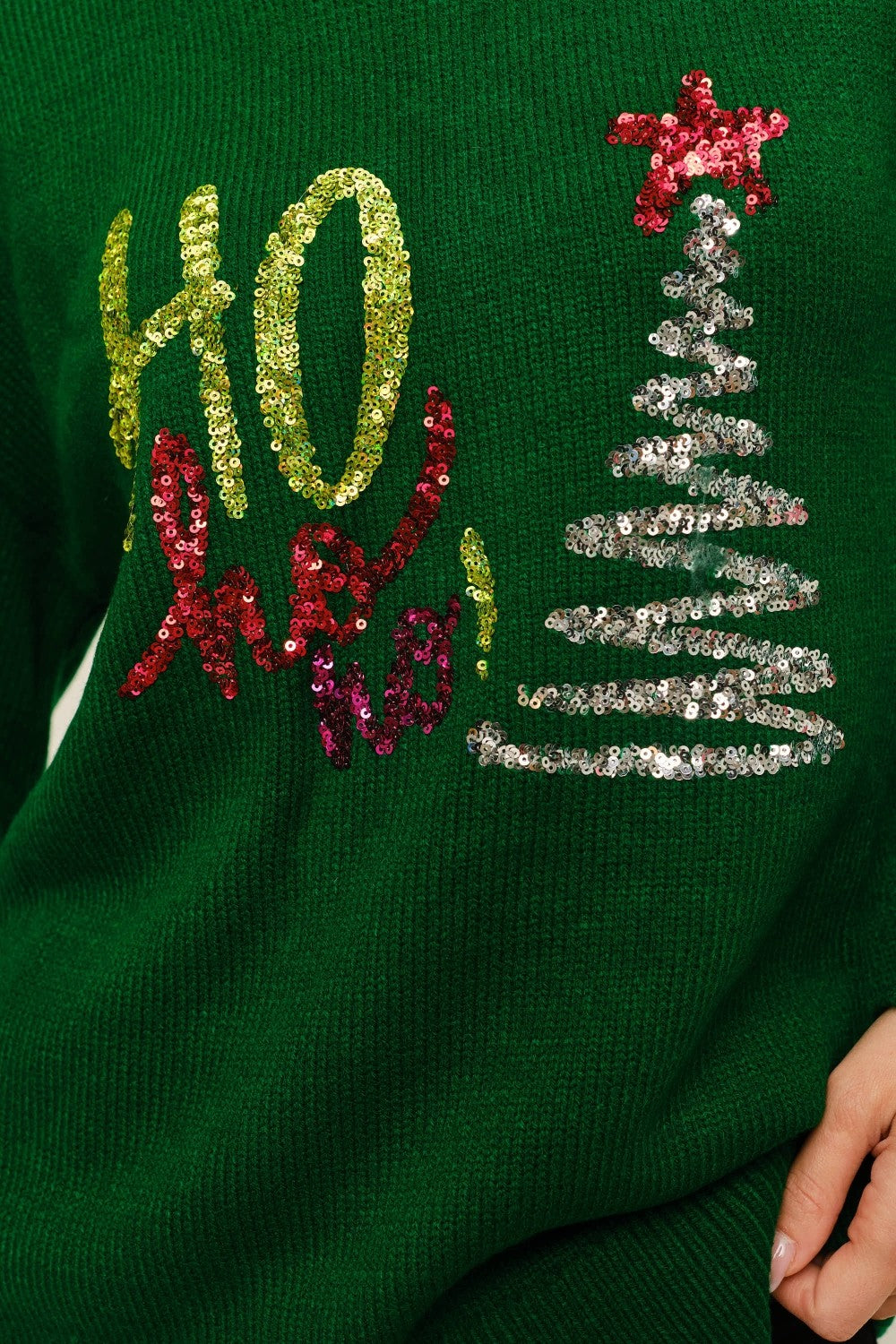 Back view of a woman in a green Christmas sweater, showing the plain back design, relaxed fit, ideal for holiday festivities.