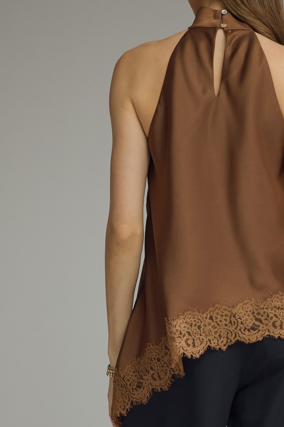 Boutique women’s satin halter tank with a high neckline, asymmetrical lace hem, and luxurious finish for elevated everyday style.