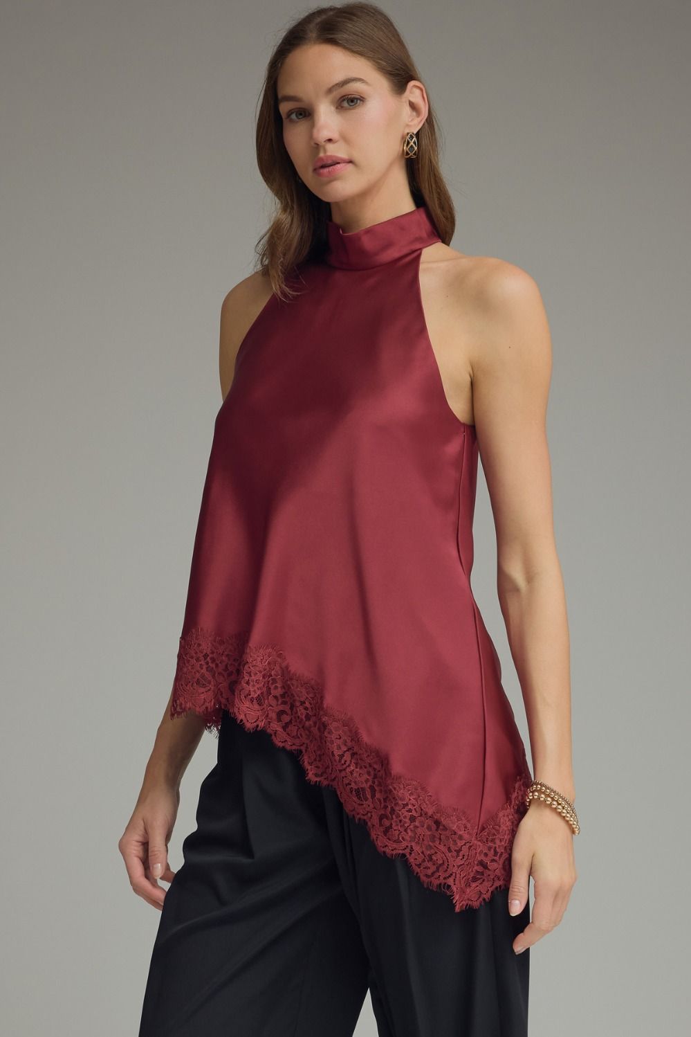Women’s elegant satin halter top with scalloped lace trim, sleeveless design, and a flattering draped fit in black, chocolate brown, and burgundy.