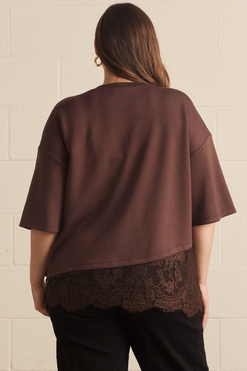 Plus size brown satin-like asymmetrical tee with relaxed fit and wide sleeves, paired with lace hem detail for stylish comfort