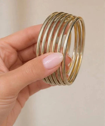 Set of six gold-toned all-weather bangles with sleek, lightweight, and flexible design, perfect for stacking or wearing alone