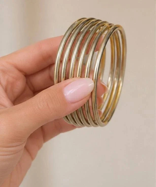 Set of six gold-toned all-weather bangles with sleek, lightweight, and flexible design, perfect for stacking or wearing alone