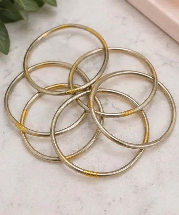 Multiple gold-colored all-weather bangles with smooth, rounded shape, ideal for casual or elegant jewelry stacks